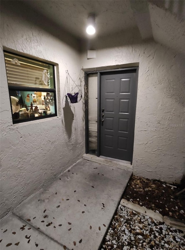 entrance to property with stucco siding