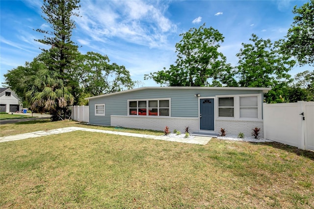 6601 13th St N, Saint Petersburg, FL 33702 - view of front of house featuring fence, a front lawn, and brick siding