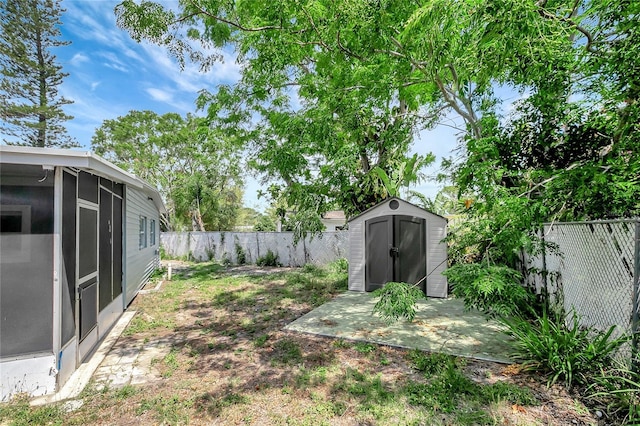 6601 13th St N, Saint Petersburg, FL 33702 - view of yard featuring a fenced backyard, an outbuilding, a sunroom, and a shed