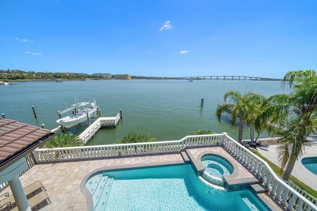 view of swimming pool with a water view and a pool with connected hot tub