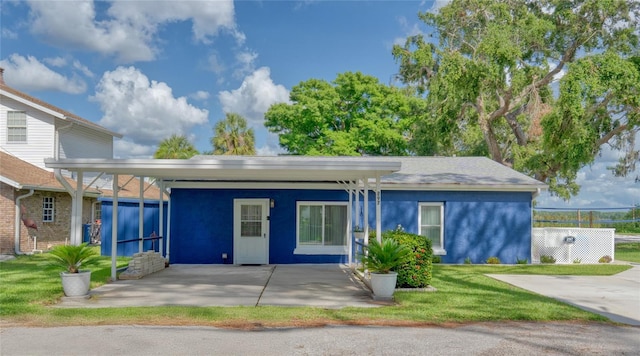 297 Lakeview Dr, Tarpon Springs, FL 34689 - back of property with stucco siding, a carport, and a yard