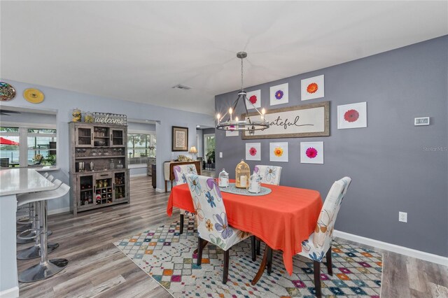 297 Lakeview Dr, Tarpon Springs, FL 34689 - dining area featuring a chandelier, healthy amount of natural light, wood finished floors, and baseboards