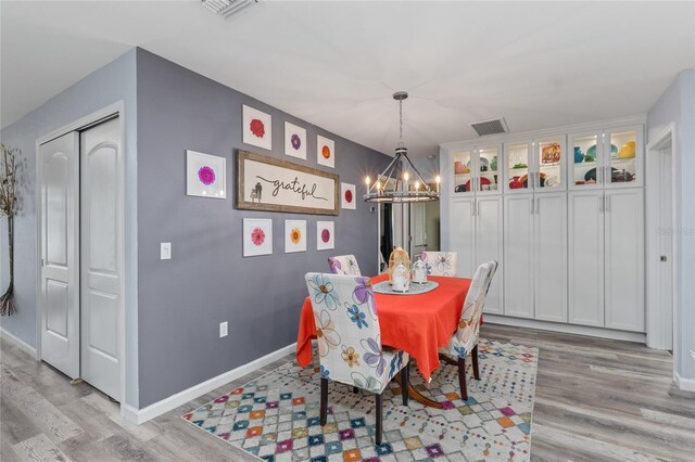297 Lakeview Dr, Tarpon Springs, FL 34689 - dining area featuring a chandelier, light wood finished floors, and baseboards