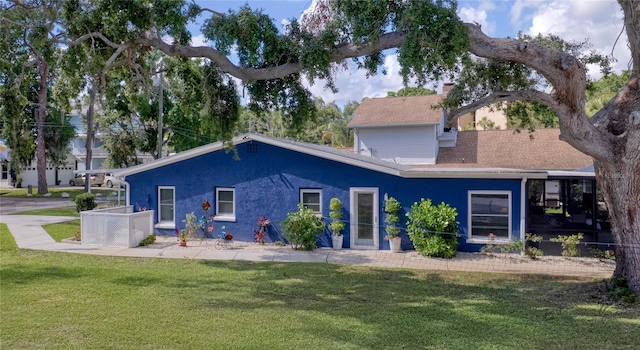 297 Lakeview Dr, Tarpon Springs, FL 34689 - back of property with a yard, stucco siding, a shingled roof, and a chimney