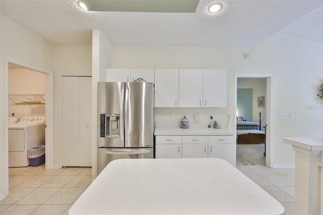 kitchen featuring stainless steel refrigerator with ice dispenser, light countertops, white cabinetry, and light tile patterned floors