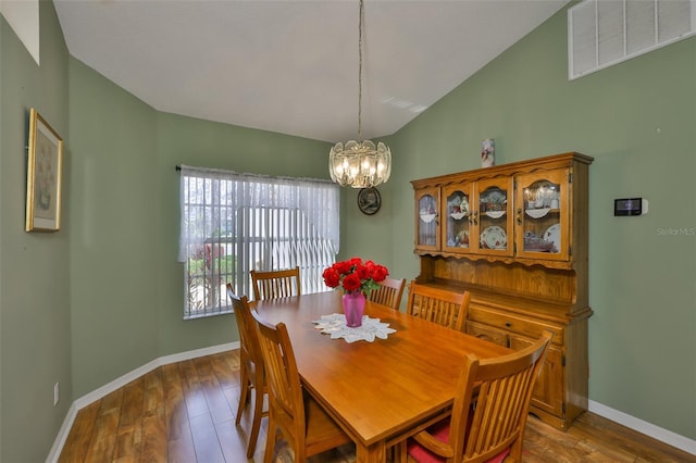 dining area featuring visible vents, baseboards, vaulted ceiling, and an inviting chandelier