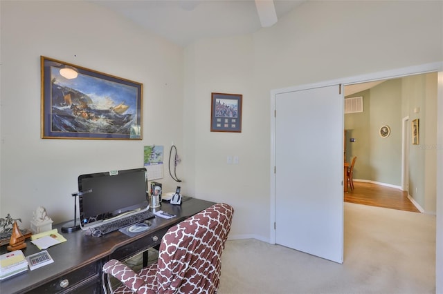 home office featuring light colored carpet, baseboards, visible vents, and ceiling fan