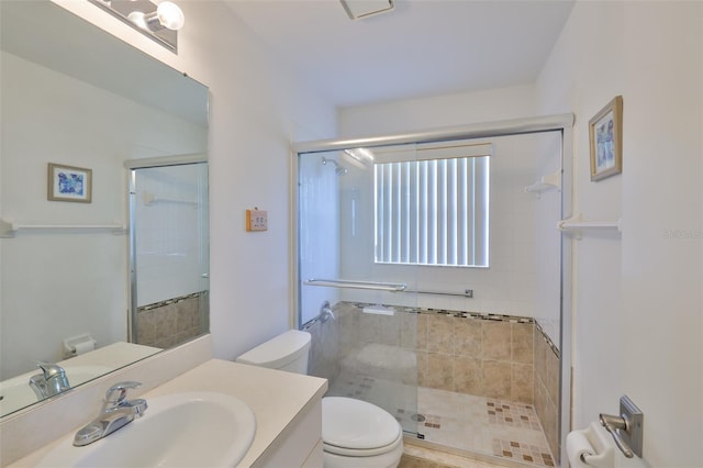full bath with vanity, a stall shower, and toilet
