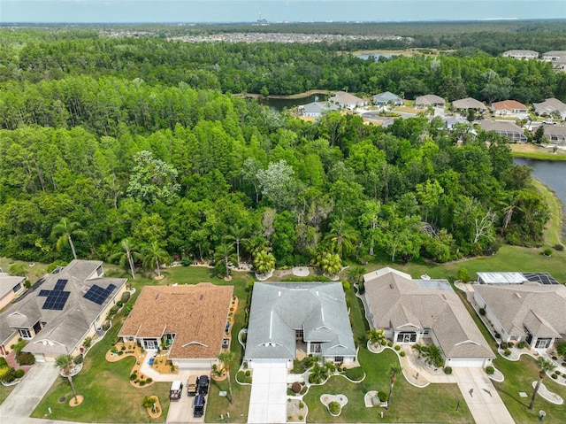 bird's eye view featuring a residential view, a water view, and a wooded view