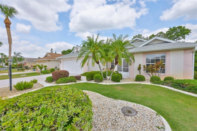 single story home with stucco siding, an attached garage, driveway, and a front yard