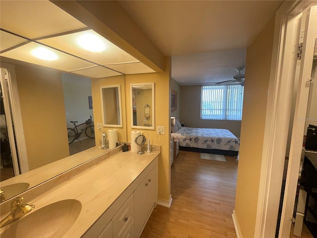 ensuite bathroom with vanity, ensuite bathroom, baseboards, and wood finished floors