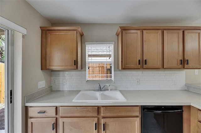 kitchen featuring black dishwasher, a healthy amount of sunlight, a sink, and tasteful backsplash