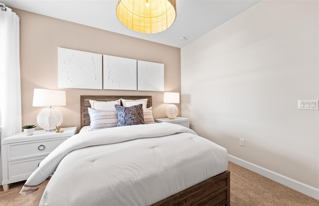 bedroom with baseboards and light colored carpet
