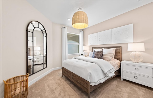 bedroom with baseboards and light carpet