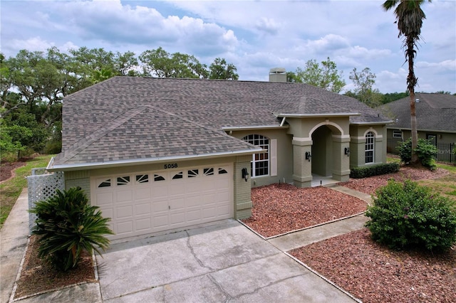 5058 Westlake Blvd, Dade City, FL 33523 - ranch-style house featuring roof with shingles, a garage, driveway, a chimney, and brick siding