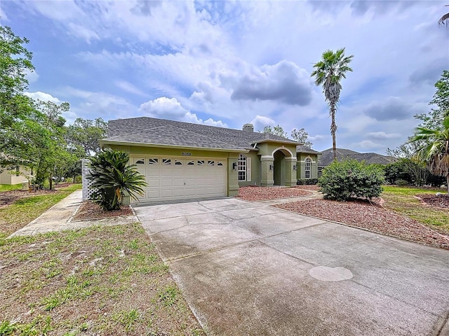 5058 Westlake Blvd, Dade City, FL 33523 - view of front of property featuring an attached garage, concrete driveway, stucco siding, and a chimney