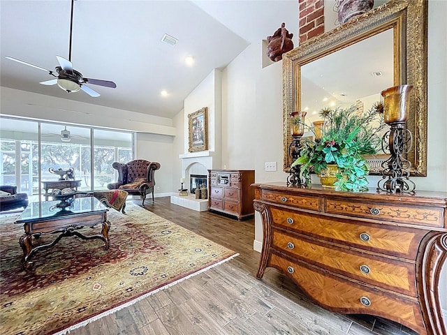 5058 Westlake Blvd, Dade City, FL 33523 - living room featuring a glass covered fireplace, a ceiling fan, wood finished floors, baseboards, and high vaulted ceiling