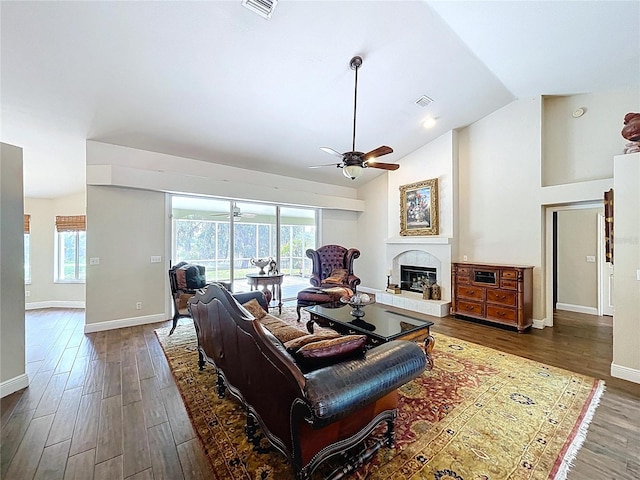 5058 Westlake Blvd, Dade City, FL 33523 - living room featuring ceiling fan, baseboards, wood finished floors, vaulted ceiling, and a glass covered fireplace