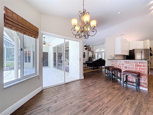 5058 Westlake Blvd, Dade City, FL 33523 - dining area with a ceiling fan, dark wood-style floors, baseboards, a chandelier, and lofted ceiling