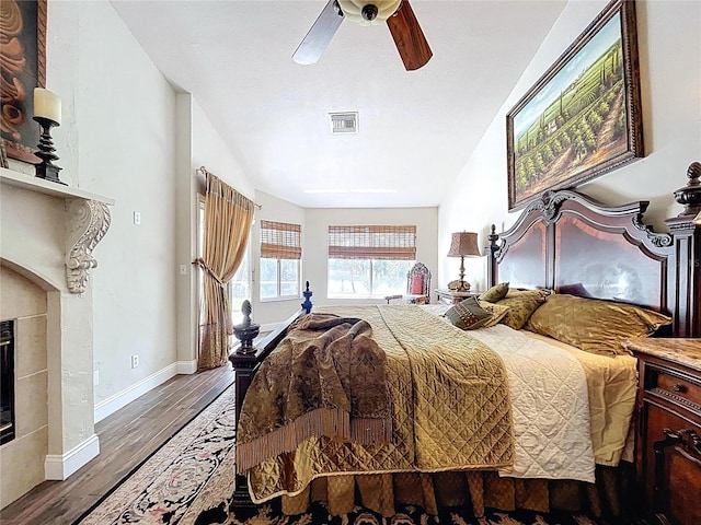 5058 Westlake Blvd, Dade City, FL 33523 - bedroom featuring wood finished floors, baseboards, a fireplace, and a ceiling fan