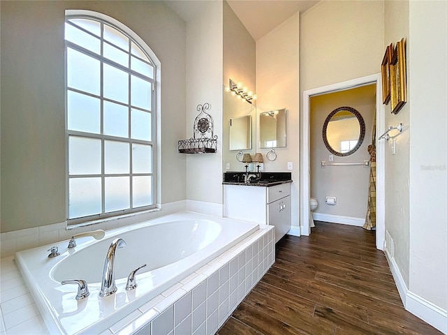 5058 Westlake Blvd, Dade City, FL 33523 - bathroom featuring toilet, a bath, vanity, wood finished floors, and baseboards