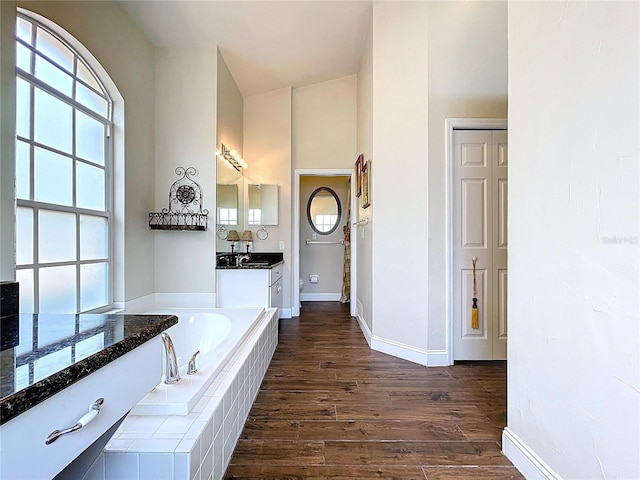 5058 Westlake Blvd, Dade City, FL 33523 - bathroom featuring a garden tub, wood finished floors, vanity, and baseboards