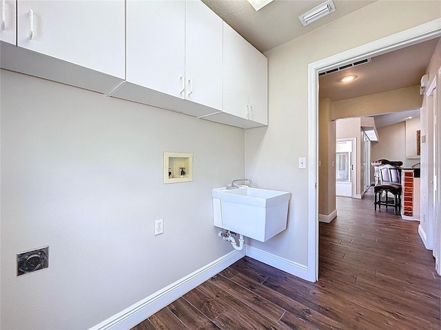 5058 Westlake Blvd, Dade City, FL 33523 - laundry area with electric dryer hookup, washer hookup, cabinet space, dark wood-type flooring, and baseboards