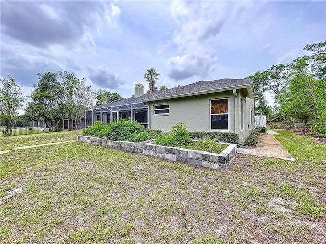 5058 Westlake Blvd, Dade City, FL 33523 - rear view of property featuring a lawn, a lanai, stucco siding, and a chimney