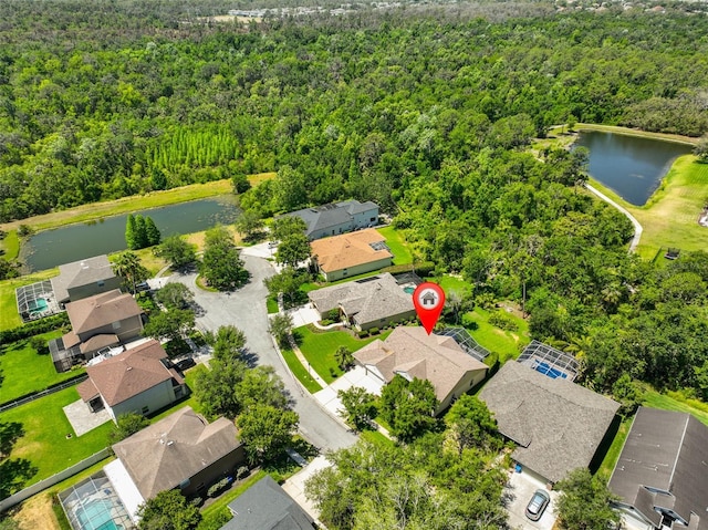 birds eye view of property featuring a residential view, a water view, and a wooded view