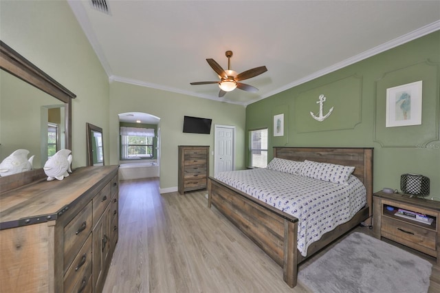 bedroom with light wood finished floors, arched walkways, baseboards, visible vents, and ornamental molding