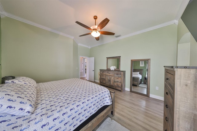 bedroom with baseboards, visible vents, ornamental molding, and wood finished floors