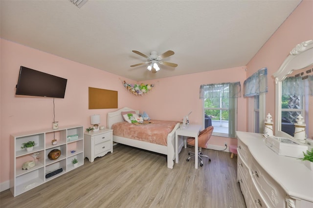 bedroom featuring light wood-style floors, baseboards, and a ceiling fan