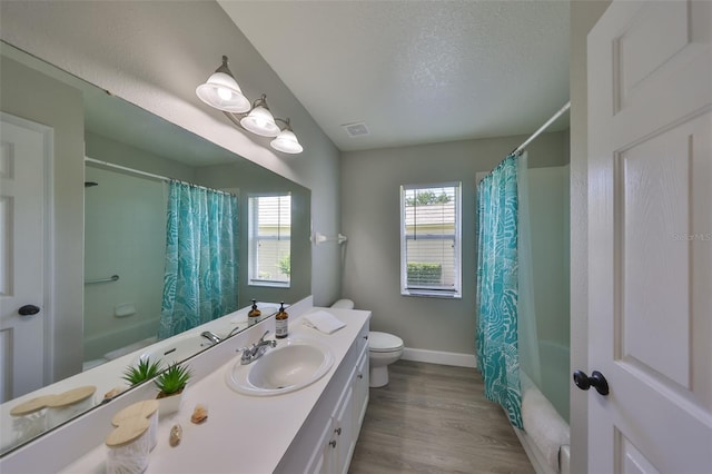 full bath with vanity, baseboards, shower / bath combo with shower curtain, and toilet