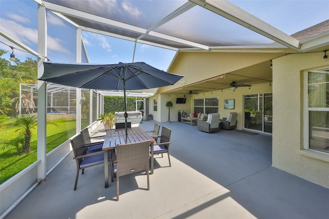 view of patio / terrace with glass enclosure, outdoor dining area, a ceiling fan, and an outdoor hangout area