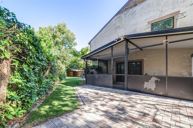 view of patio / terrace with fence and a sunroom