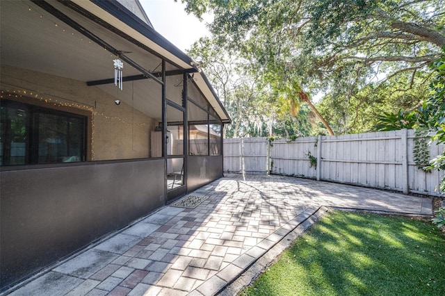 view of patio featuring a sunroom and fence