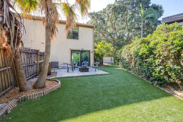 view of yard featuring a patio, a fenced backyard, an outdoor fire pit, and central AC