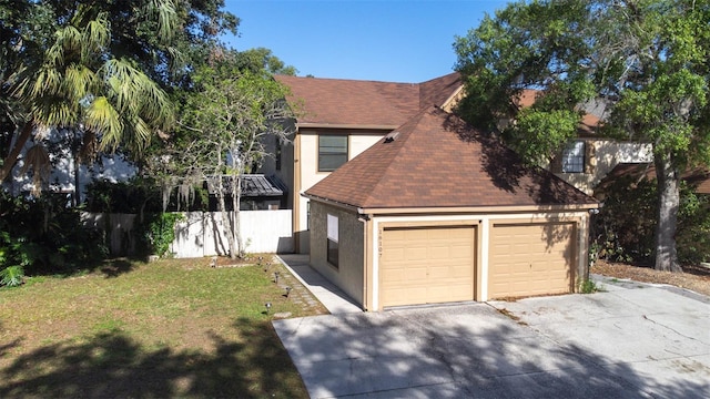 view of front of house with roof with shingles, a garage, stucco siding, a front yard, and driveway
