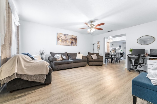 living room with a ceiling fan, light wood-type flooring, and visible vents