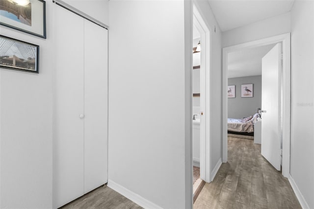hallway featuring baseboards and light wood-style floors