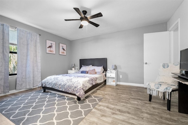 bedroom featuring baseboards, a ceiling fan, and wood finished floors