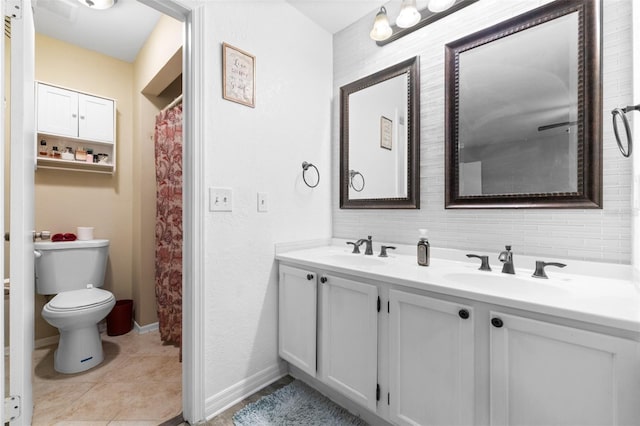 bathroom featuring double vanity, toilet, a sink, and tile patterned floors