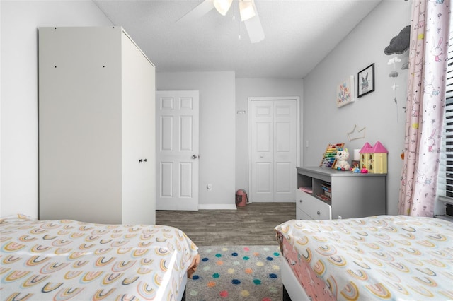 bedroom with baseboards, ceiling fan, wood finished floors, and a closet