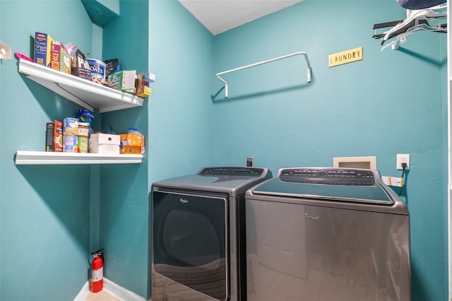 washroom with laundry area, baseboards, and washer and dryer