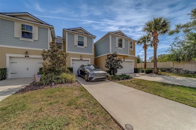 view of front facade featuring concrete driveway, an attached garage, fence, and stucco siding