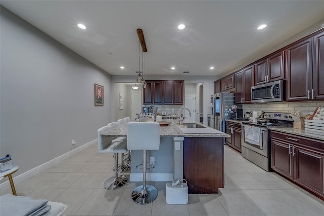 kitchen featuring decorative backsplash, a breakfast bar area, recessed lighting, a sink, and appliances with stainless steel finishes