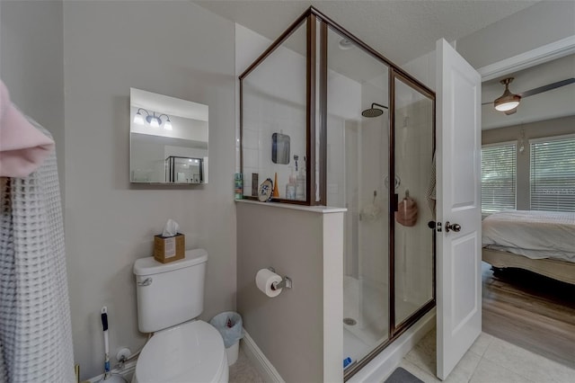 ensuite bathroom with toilet, connected bathroom, tile patterned floors, a shower stall, and a ceiling fan