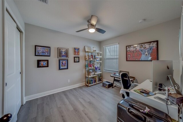 office space with baseboards, ceiling fan, and wood finished floors