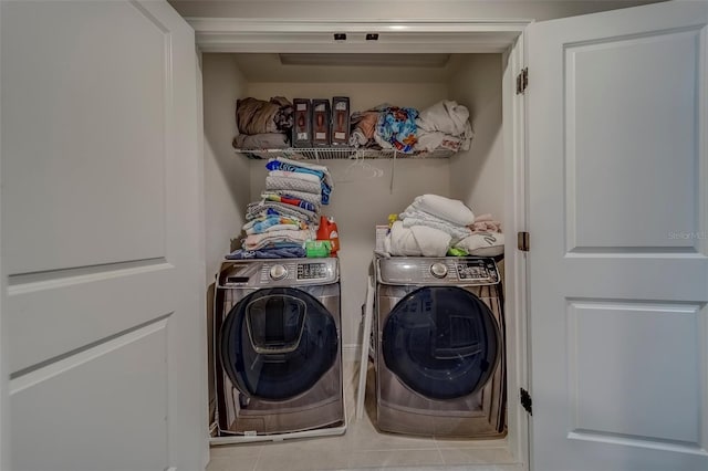 washroom featuring laundry area, tile patterned floors, and washing machine and clothes dryer