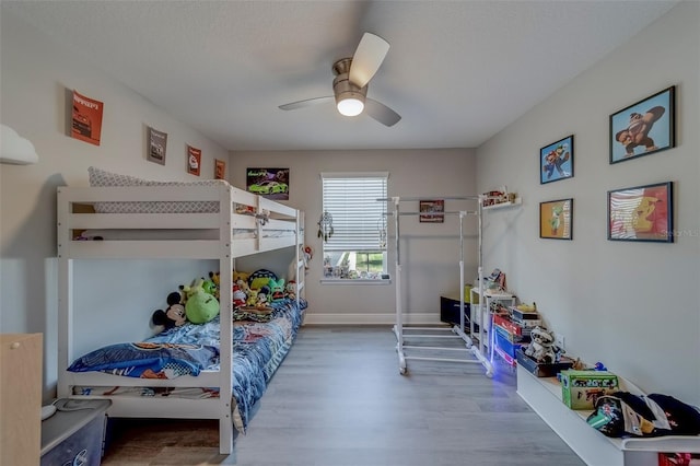 bedroom featuring baseboards, ceiling fan, and wood finished floors